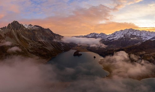 Aerial view over the fog and Lake Sils shortly in front of sunrise in autumn
