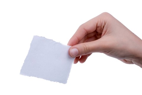 Hand holding a piece of blank torn notepaper