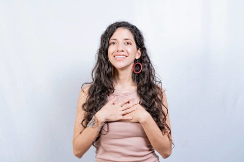 Positive woman with lovely sincere smile feeling thankful