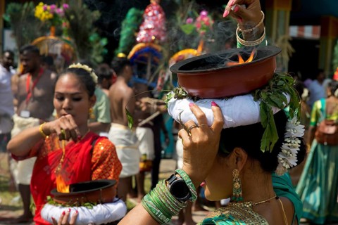 A Hindu woman carries a fire bowl during the big procession Theer