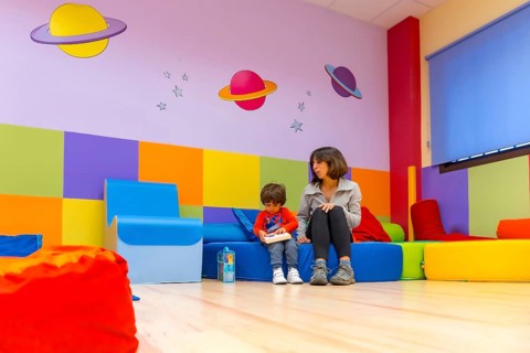 Woman teacher playing with a child sitting reading a book