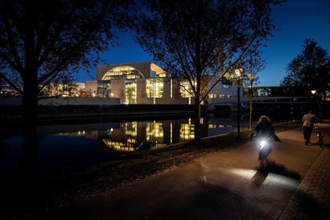 Cyclists in front of the Federal Chancellery at blue hour