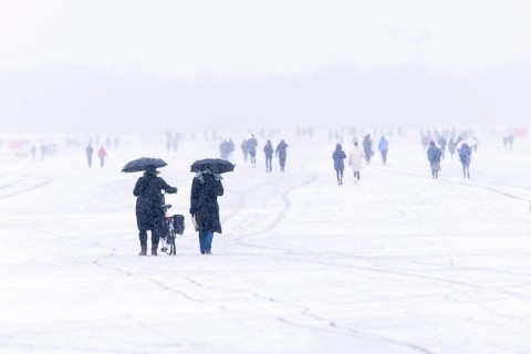 Berliners walk across Tempelhofer Feld in Berlin during snowfall
