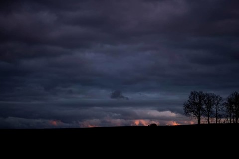 A car stands out on a country road at blue hour in Vierkirchen