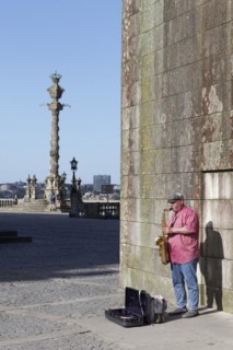 Street musician playing saxophones in front of the Se do Porto Cathedral