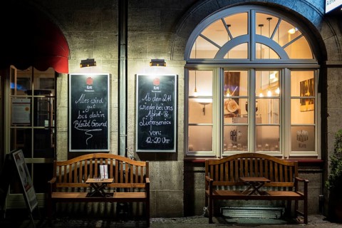 Two signs at a restaurant indicate meals 'to go' in Berlin