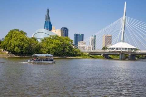 View from the Tache Promenade onto the Red River with Provencher Bridge and the skyline of Winnipeg behind