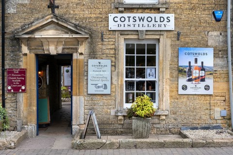 Old stone house in detail with sales shop of the Cotswolds Distillery in the old town of Bourton on the Water