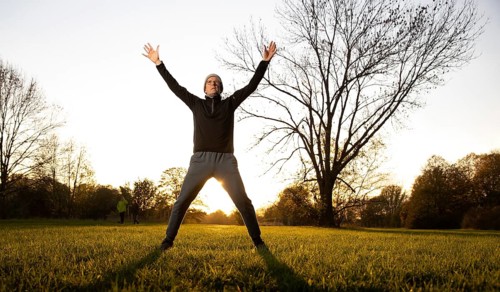 Man doing early morning exercise in autumn in a meadow.