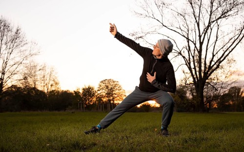 Man doing chi gong outdoors in the evening light