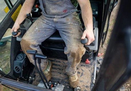 A construction worker controls the levers of an excavator. Berlin