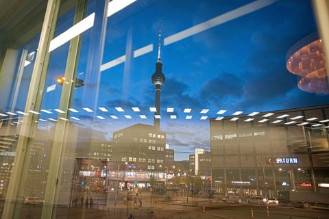 The TV tower at Alexanderplatz is reflected in a disc at blue hour. Berlin