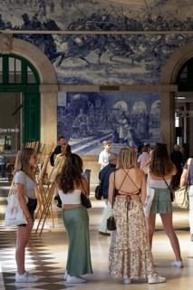 Young female tourist looking at the azulejos at Porto Sao Bento station