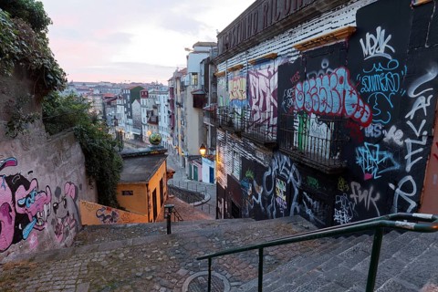 Steep staircase alley with wild graffiti at dusk