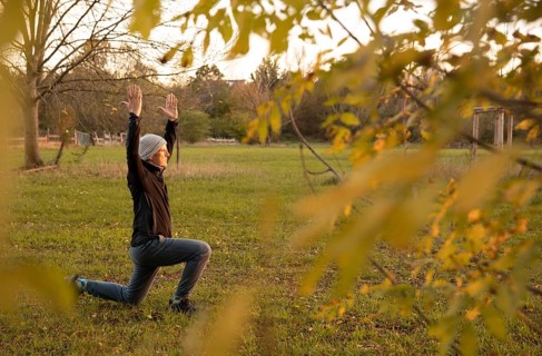 Man stretching in a meadow in autumn. Yoga outdoors.