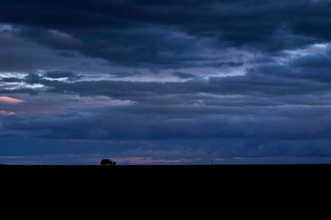 A car stands out on a country road at blue hour in Vierkirchen
