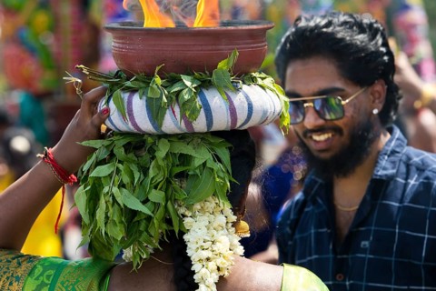 A Hindu woman carries a fire bowl during the big procession Theer
