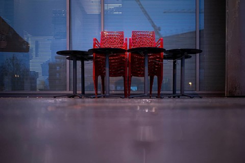 Assembled chairs and tables stand out in front of a closed cafe in Berlin