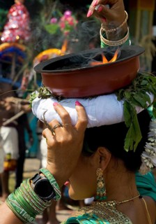 A Hindu woman carries a fire bowl during the big procession Theer