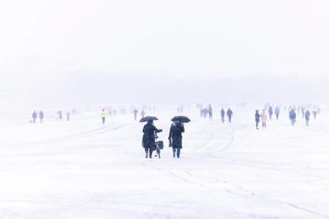 Berliners walk across Tempelhofer Feld in Berlin during snowfall