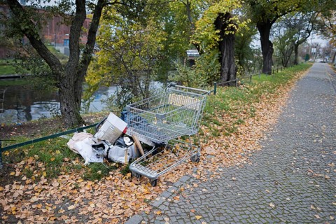 Illegal waste disposal. A shopping trolley and rubbish lie on a pavement in Berlin Moabit. Berlin