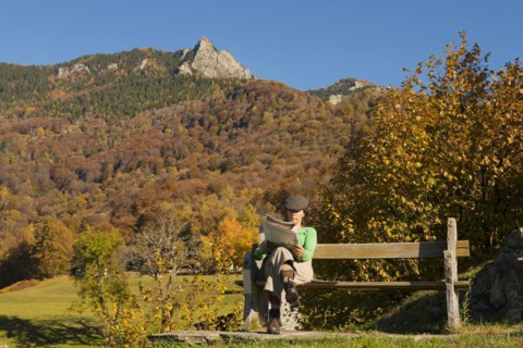 Woman sitting on a bench and reading newspaper