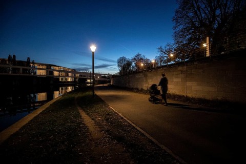 A woman with a pram stands out on the Spreebogen at blue hour