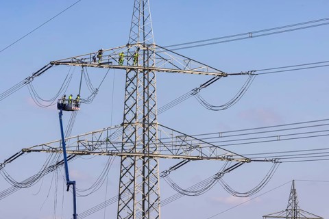 High-voltage pylon with fitters with cherry picker
