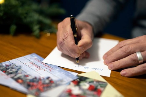 Merry Christmas. Man writes Christmas cards by hand