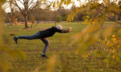 Man stretching in a meadow in autumn. Outdoor sports.