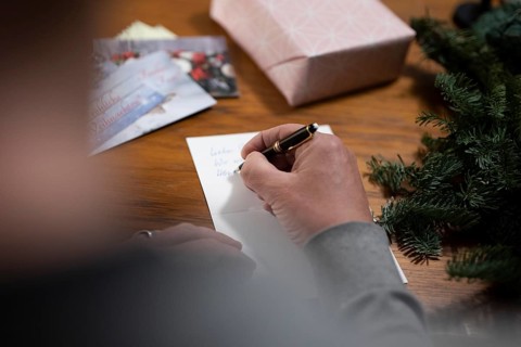 Merry Christmas. Man writes Christmas cards by hand