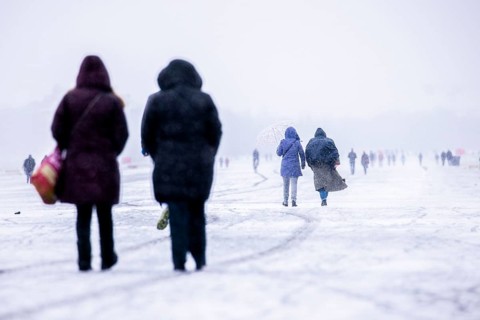 Berliners walk across Tempelhofer Feld in Berlin during snowfall