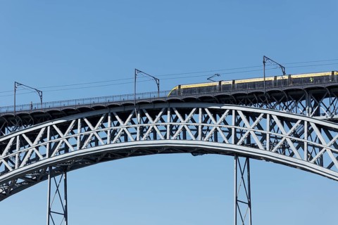 Metro do Porto train crossing the Ponte D. Luis I truss arch bridge