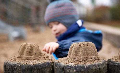 Child sitting alone in a playground.