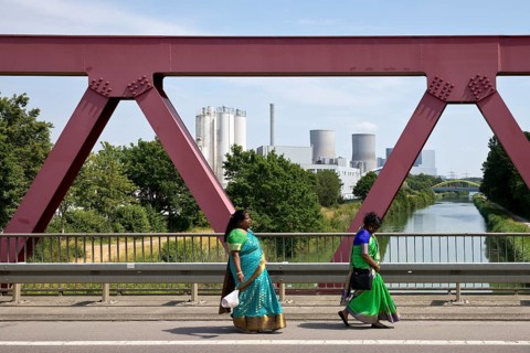 Two woman in traditional saris on their way to the temple festival in front of industry at the Datteln-Hamm canal