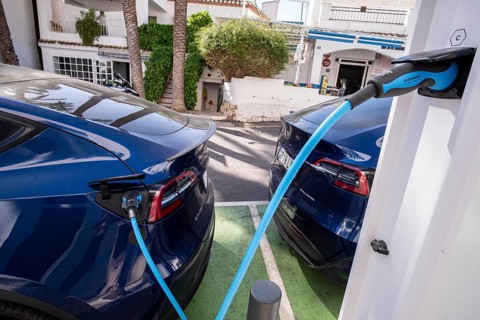 Two Tesla electric vehicles charging at a charging station in the village of Altea La Vella