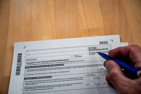Male hand with biros in front of income tax declaration form