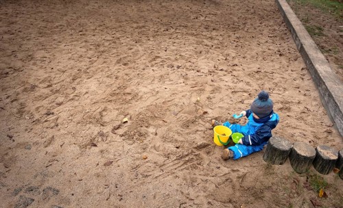 Child sitting alone in a playground.