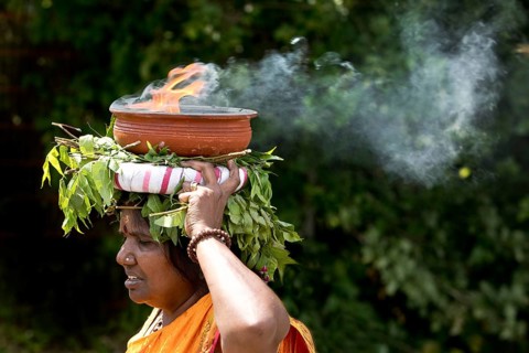 A Hindu woman carries a fire bowl during the big procession Theer