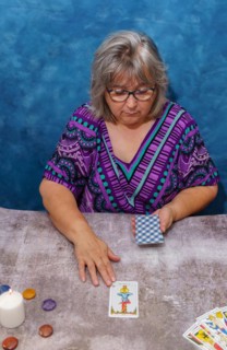 Older white haired woman pythoness casting tarot cards