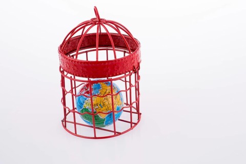 Small globe trapped in a red birdcage