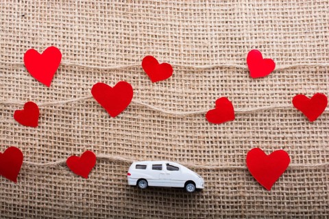 Love concept with car and paper heart on linen threads