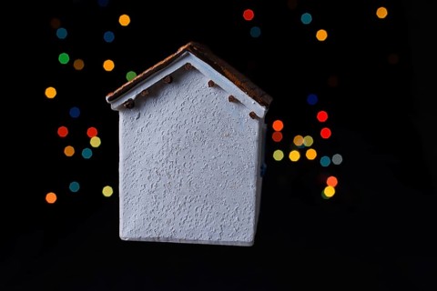 Little model house on a bokeh ligh ton a dark background