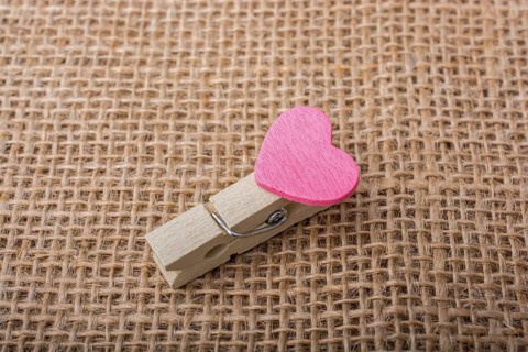 Colorful heart attached to a clothespin in hand