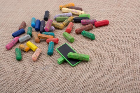 Used crayons of various color and a notice board