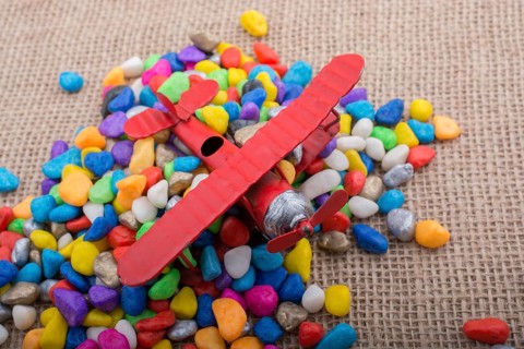 Pile of little colorful pebbles on wooden background