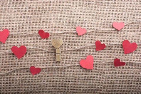 Love concept with heart shaped papers on linen threads