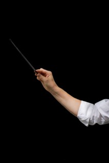 Arm of male conductor with baton isolated on black background