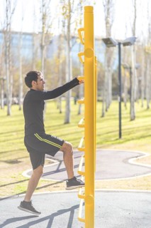 Young man doing climbing vertical exercise in the park