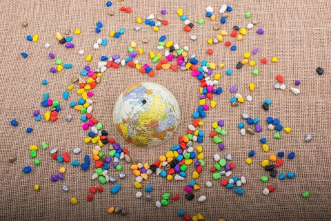 Globe in the heart form shaped by colorful pebbles